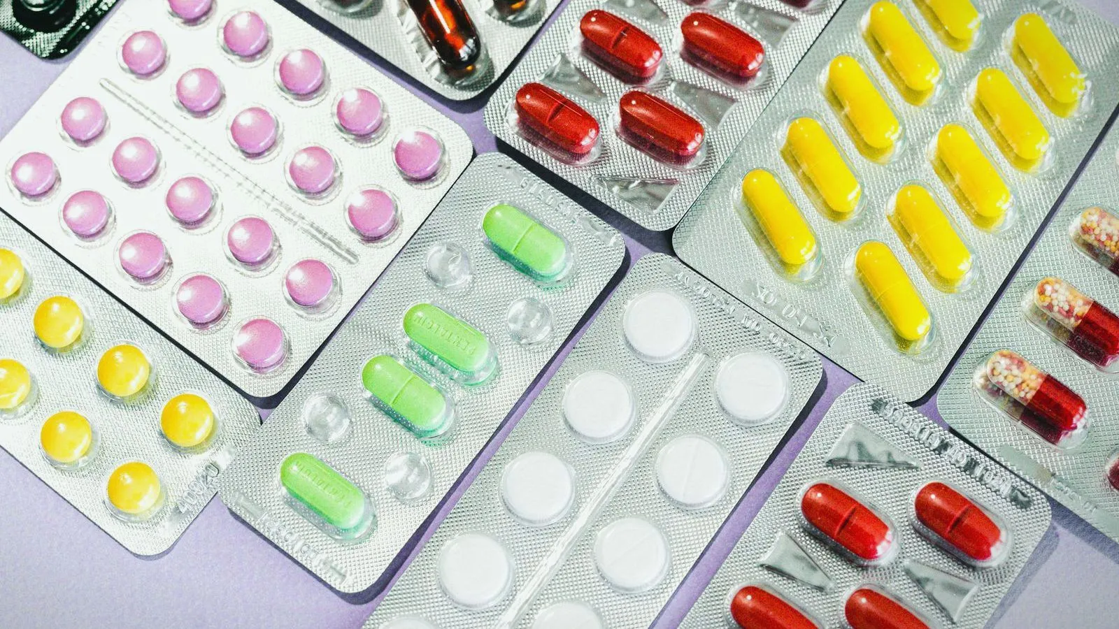 Overlapping blister packs holding many different coloured tablets and capsules
