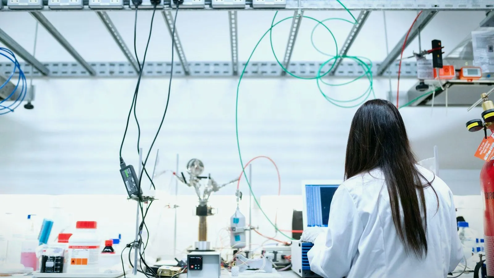 A scientist working at a laboratory bench lined with instruments
