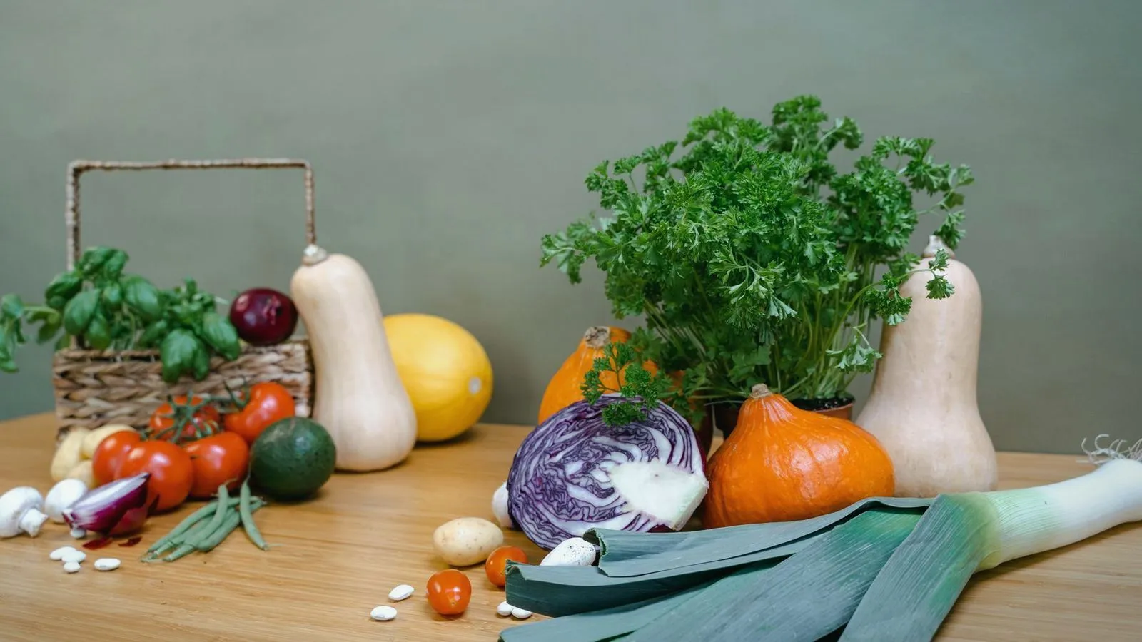 Fresh vegetables and herbs spread across a wooden table