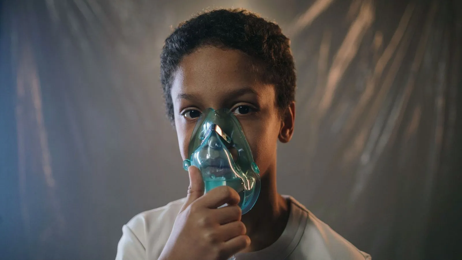 A child holding a nebulizer mask to their face